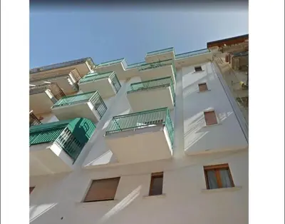 a tall white building with green balconies on it at Sofi apartment in Palermo
