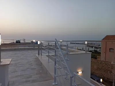 a staircase on top of a building with a view of the ocean at A casa di nonna Maria in Terrasini