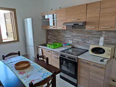 a kitchen with a table and a stove top oven at A casa di nonna Maria in Terrasini