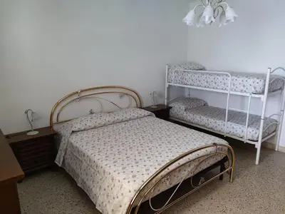 a bedroom with a bed and two bunk beds at A casa di nonna Maria in Terrasini