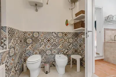 a bathroom with a toilet and a sink at GuestHost - Vucciria Market Apartment with Balconies in Palermo