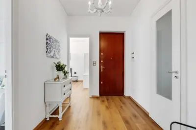 a hallway with white walls and a wooden door at GuestHost - Residenza dei Poeti - Roomy and Modern Flat in Palermo