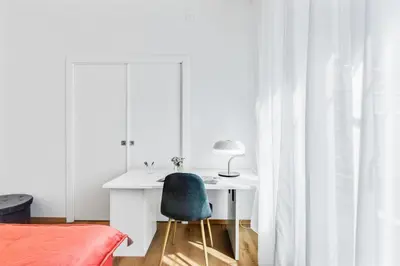 a bedroom with a desk and a blue chair at GuestHost - Residenza dei Poeti - Roomy and Modern Flat in Palermo