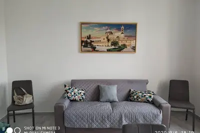 a living room with a couch and a picture on the wall at Home sweet home appartamento ricco di comfort in Palermo
