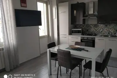 a kitchen with a white table and chairs and a table and a kitchen at Home sweet home appartamento ricco di comfort in Palermo
