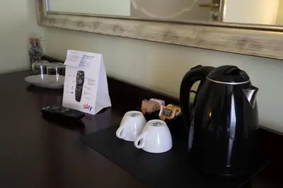 a black coffee pot sitting on a counter with a remote control at Hotel Borgo di Ciàula in Santa Flavia
