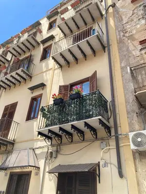 a building with a balcony with flowers on it at Apartament la Lumaca Kalsa in Palermo
