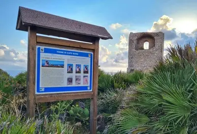 a sign in the middle of a field with a building at Il moro - Casa Vacanze in Terrasini