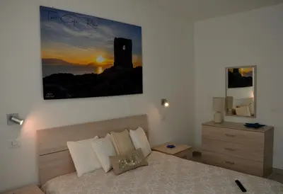 a bedroom with a bed and a painting on the wall at PESCA AZZURRA in Terrasini
