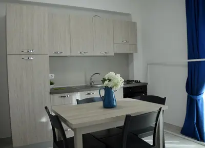 a kitchen with a table with a vase of flowers on it at PESCA AZZURRA in Terrasini