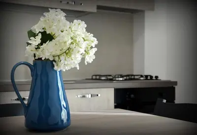 a blue vase filled with white flowers on a table at PESCA AZZURRA in Terrasini