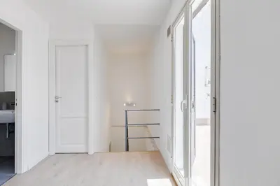 a hallway with white walls and glass doors at GuestHost - BallarHost - Ballarò Market Terrace Apartment in Palermo