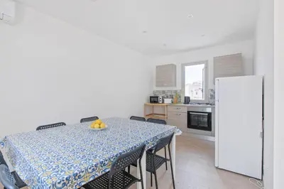 a kitchen with a table with chairs and a refrigerator at GuestHost - BallarHost - Ballarò Market Terrace Apartment in Palermo