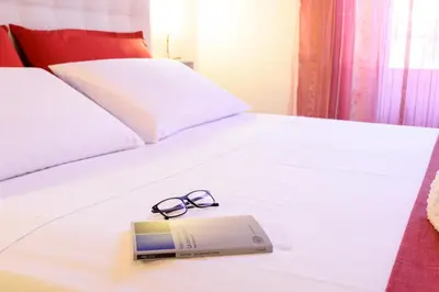 a pair of glasses and a book on a bed at HouseStation in Palermo
