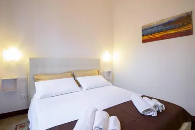 a bedroom with a large white bed with towels on it at HouseStation in Palermo