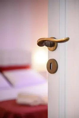 a door knob on a white door with a bed at HouseStation in Palermo