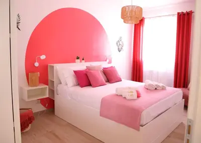 a red and white bedroom with a bed with pink pillows at Golden Holiday Villas Private Pools in Sicily in Terrasini