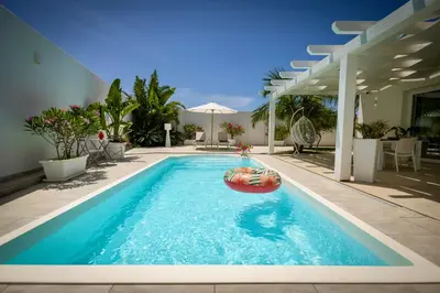 a swimming pool with a raft in the middle at Golden Holiday Villas Private Pools in Sicily in Terrasini