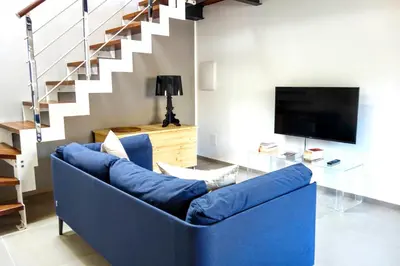 a blue couch in a living room with a staircase at Le dimore di Palagonia in Bagheria