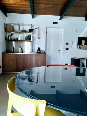 a glass table and a chair in a room at Le dimore di Palagonia in Bagheria