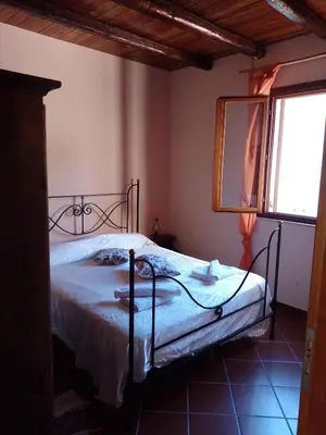a bedroom with a bed and a mirror and a window at Casa vacanze Butterfly in Trabia