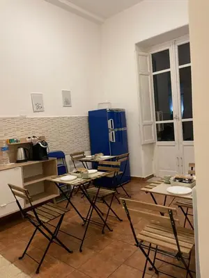 a room with tables and chairs and a refrigerator at 100 PASSI al Massimo in Palermo