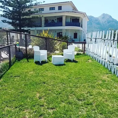 a fence with white chairs in front of a house at Villa Michelangelo in Castellammare del Golfo