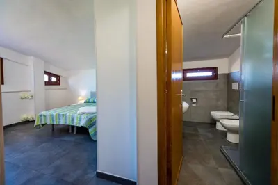 a bathroom with a bed and a toilet in a room at Villa Michelangelo in Castellammare del Golfo