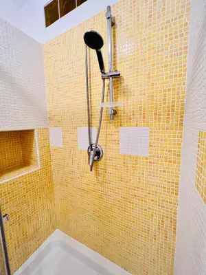 a shower with a yellow tiled wall at B&B Vivaldi in Palermo