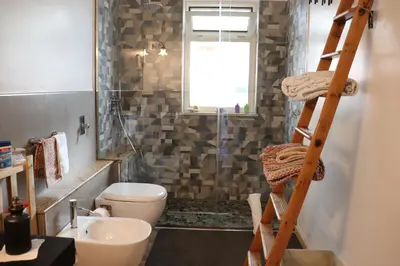 a bathroom with a toilet a sink and a ladder at Casavacanze Tuttapposto in Palermo