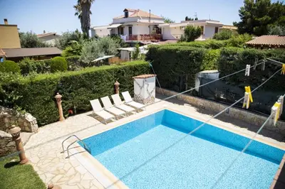 a swimming pool with two chairs and a house at Dimora Fanale, Villa Esclusiva con Piscina Privata - Fanale Rentals in Altavilla Milicia