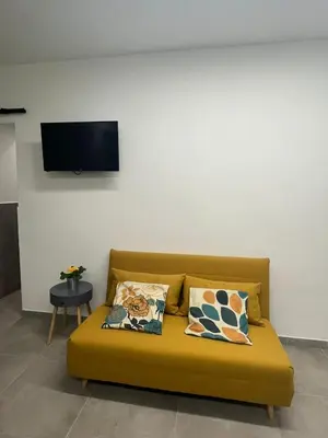a yellow couch with two pillows in a room at Kemonia Home Palermo in Palermo