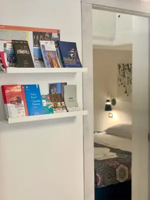 a book shelf with books in a bedroom at Kemonia Home Palermo in Palermo
