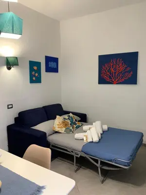 a living room with a couch and a blue bed at Kemonia Home Palermo in Palermo