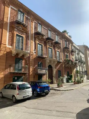 two cars parked in front of a brick building at Kemonia Home Palermo in Palermo