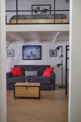 a living room with a couch and a loft bed at Loft Mercede al Capo in Palermo