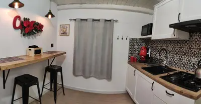 a kitchen with white cabinets and a sink and a counter at Loft Mercede al Capo in Palermo