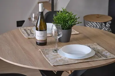 a wooden table with a bottle of wine and a plate at Loft Mercede al Capo in Palermo