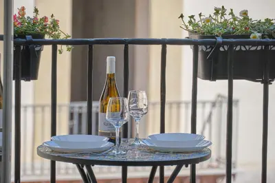 a table with a bottle of wine and two glasses at Loft Mercede al Capo in Palermo