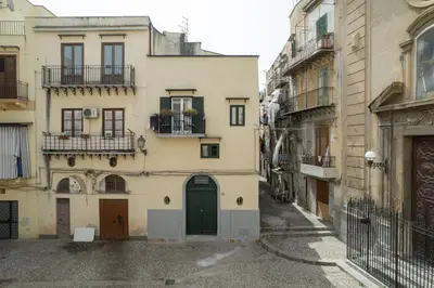 an alley in an old building with a green door at Loft Mercede al Capo in Palermo