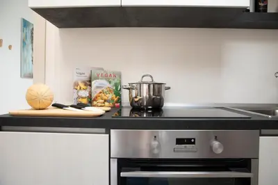 a kitchen with a stove with a pot and a cutting board at Appartamento Limone in Splendida villa Nature al mare di Scopello Zingaro in Scopello