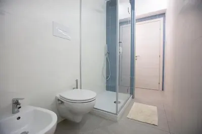 a white bathroom with a toilet and a shower at Appartamento Limone in Splendida villa Nature al mare di Scopello Zingaro in Scopello