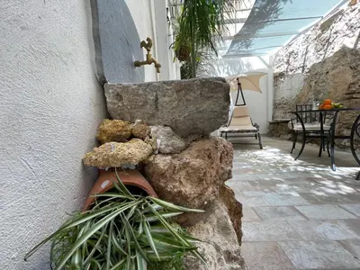 a room with a stone sink on a wall at Tufoletto Apartment in Palermo