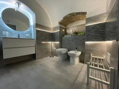 a bathroom with a toilet and a sink and a mirror at Tufoletto Apartment in Palermo