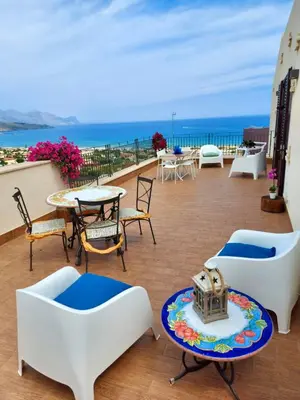 a balcony with tables and chairs and a view of the ocean at Terrazza del Golfo in Castellammare del Golfo