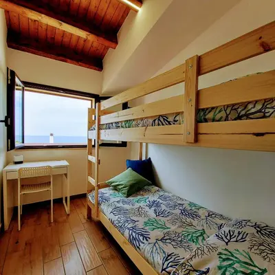 a bedroom with two bunk beds and a desk at Terrazza del Golfo in Castellammare del Golfo