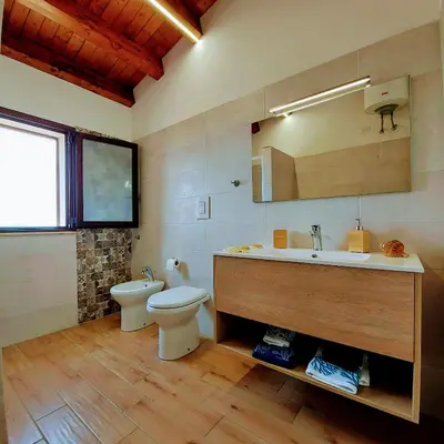 a bathroom with a toilet and a sink and a mirror at Terrazza del Golfo in Castellammare del Golfo