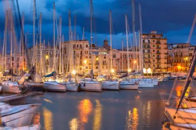 a group of boats docked in a harbor at night at Piazza Marina Apartment in Palermo