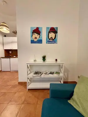 a living room with a white table with pictures on the wall at Piazza Marina Apartment in Palermo