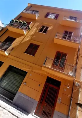 a yellow building with windows and balconies at Historic Centre - Apartment Near Teatro Massimo in Palermo